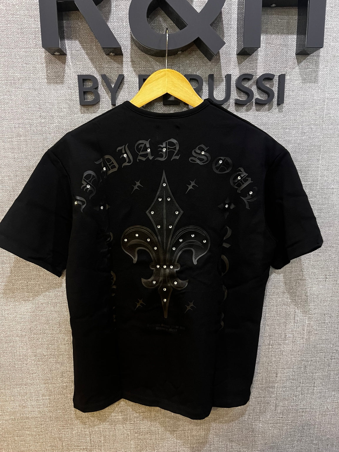 Playera Oversize Fleur de Lis R&H negra vista posterior con pedrería y flor de lis